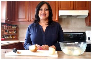 Ayisha peeling potatoes in her kitchen