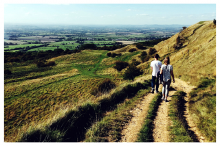 2 people walking along a path on a hillside