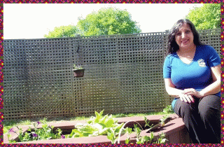 Ayisha sitting near her flower planter on her deck