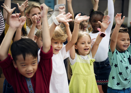 Photo of children cheering with arms raised.
